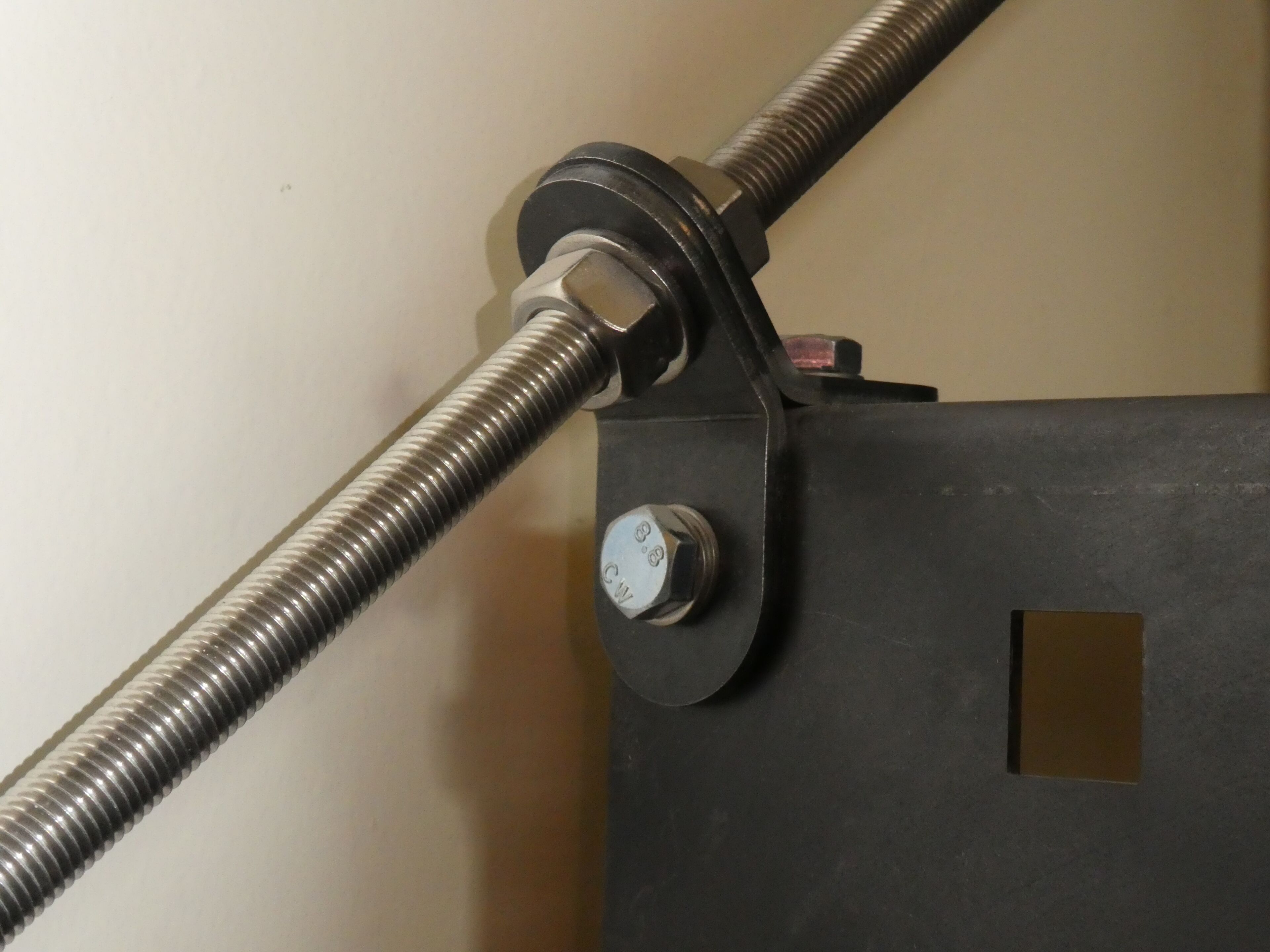 A mechanical setup with a metal rod and a black box with a square cutout.