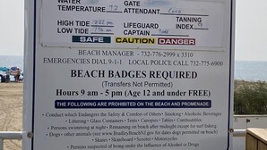 Segnale sulla spiaggia con informazioni su Bradley Beach, Newark Avenue, inclusi temperatura dell'acqua, orari di alta e bassa marea, addetto al gate, capitano dei bagnini e contatti dell'amministratore della spiaggia.