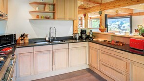 A modern kitchen with wooden cabinets, a stainless steel sink, and a red toaster.