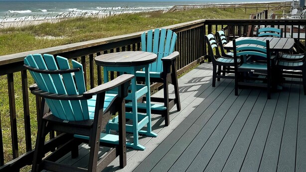 A wooden deck with outdoor seating and a view of the ocean. - 3 bed/2 bath private oceanfront home with direct beach access on Amelia Island! (fernandina beach)