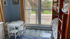 A room with a window, a bunk bed, a table with chairs, and a small white dresser. - 3 bed/2 bath private oceanfront home with direct beach access on Amelia Island! (fernandina beach)