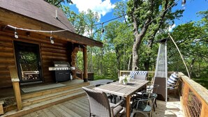 A wooden deck with a grill and outdoor seating area.