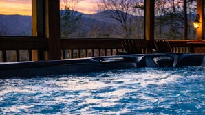 Un jacuzzi con vistas a las montañas al atardecer.