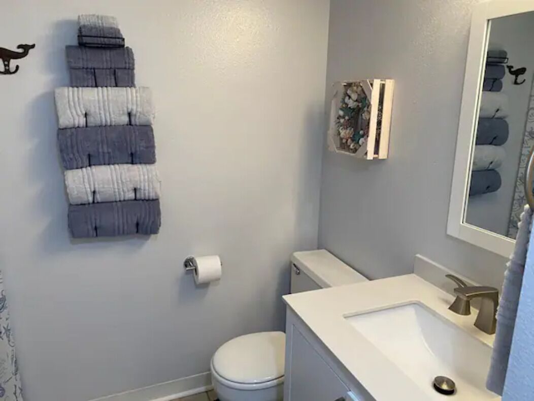 Une salle de bain équipée de toilettes, d’un lavabo et d’un porte-serviettes.