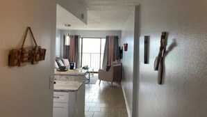 A modern kitchen with white cabinets and a herringbone tile floor. - Great studio, wonderful amenities, OCEAN views! (Galveston)