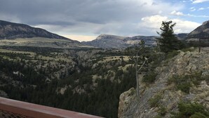 A mountainous landscape with a rocky outcrop and a tree.