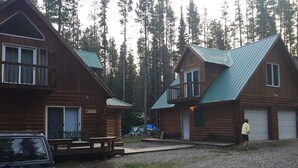 A cabin with a porch and a covered picnic table.