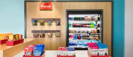 Un expositor de comestibles con botanas, bebidas y productos envasados.