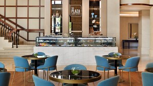 A lobby with a central counter displaying pastries and a sign reading "The Plaza Lobby & Cafe". - Crowne Plaza Dubai Jumeirah by IHG (Dubai)