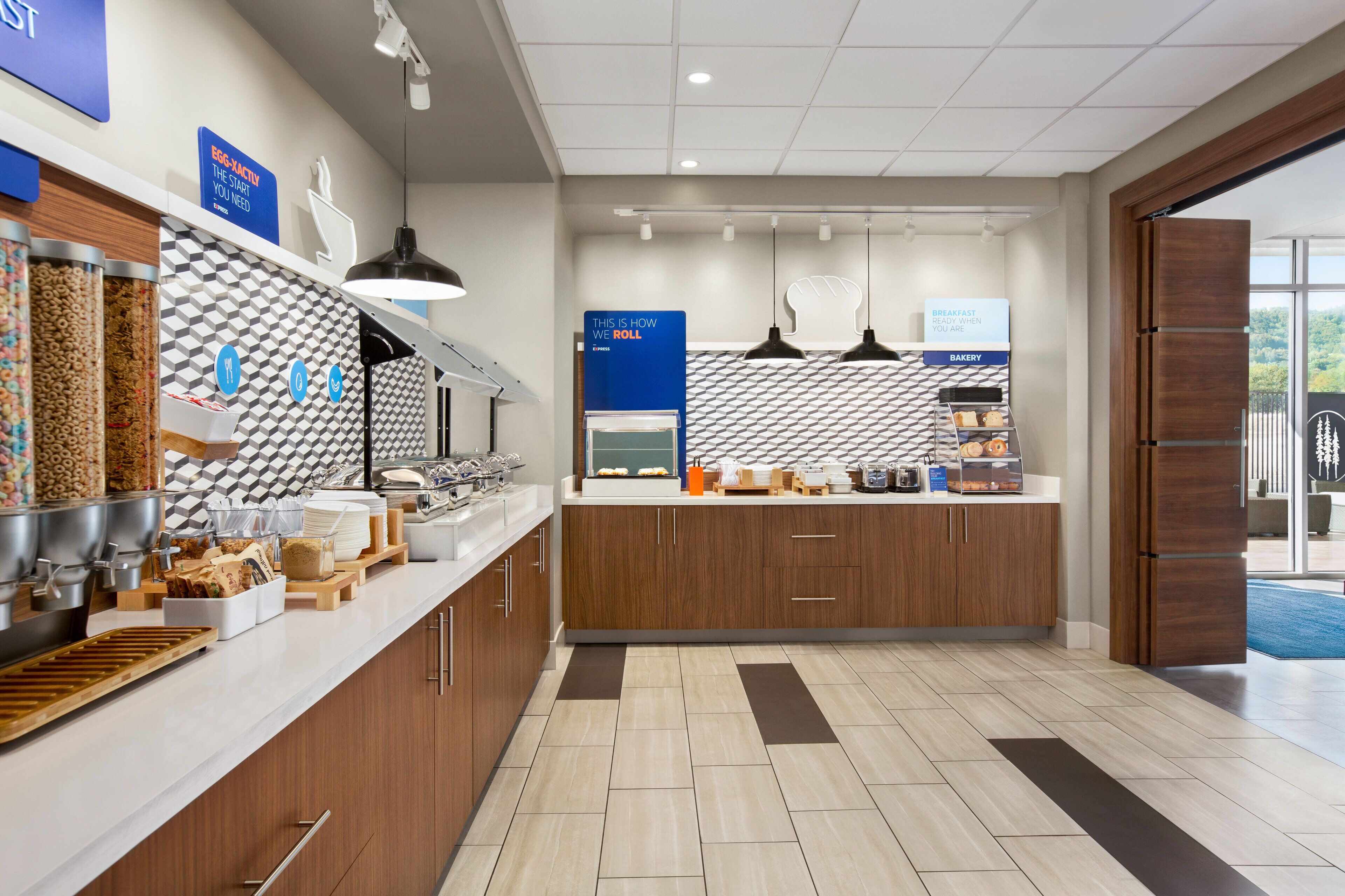 A modern breakfast area with a counter, food dispensers, and a bakery section.