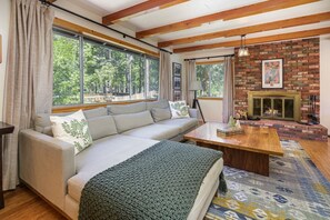 A cozy living room with a sofa, coffee table, and fireplace.