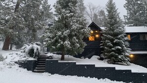 Eine Hütte mit einer Steinwand und einer Holztreppe, die zum Eingang führt.