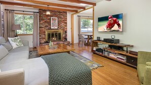 Ein Wohnzimmer mit Kamin, Fernseher und Bücherregal.