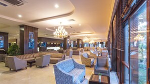 A spacious lobby with multiple seating areas, including sofas and armchairs, and a large chandelier. - Club Hotel Turan Prince World Select Villa (Manavgat)