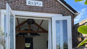 A cozy bedroom with a bed, a chair, and a sign above the door that reads "Be so Suite". - Be So Suite : Perfect getaway for 2 (Zandvoort)