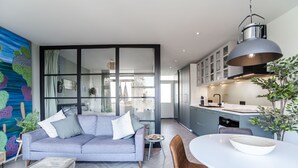 Una cocina moderna con comedor, un sofá y un amplio ventanal.