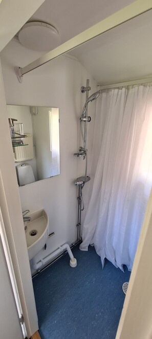 A bathroom with a sink, mirror, shower, and a white curtain. - Hel Stuga för 4 i Härlig Bymiljö (Dalarnas län)