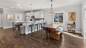A spacious kitchen with a central island, bar stools, and pendant lighting. - Family fun home with hot tub, arcade and zipline (Coeur d'Alene)