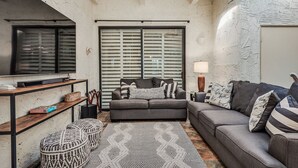 A cozy living room with a grey sofa, patterned rug, and a coffee table. - Endless views in Indian Wells!  Desert Horizons new and improved in 2024! (Indian Wells)