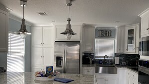 A modern kitchen with white cabinets, stainless steel appliances, and granite countertops.