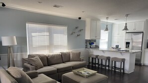 A modern living room with a sectional sofa, ottoman, and a small coffee table.
