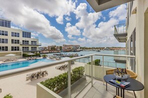 A balcony with a view of a marina, a swimming pool, and lounge chairs. - Tranquility inside, astonishing Harbor view (Oranjestad)
