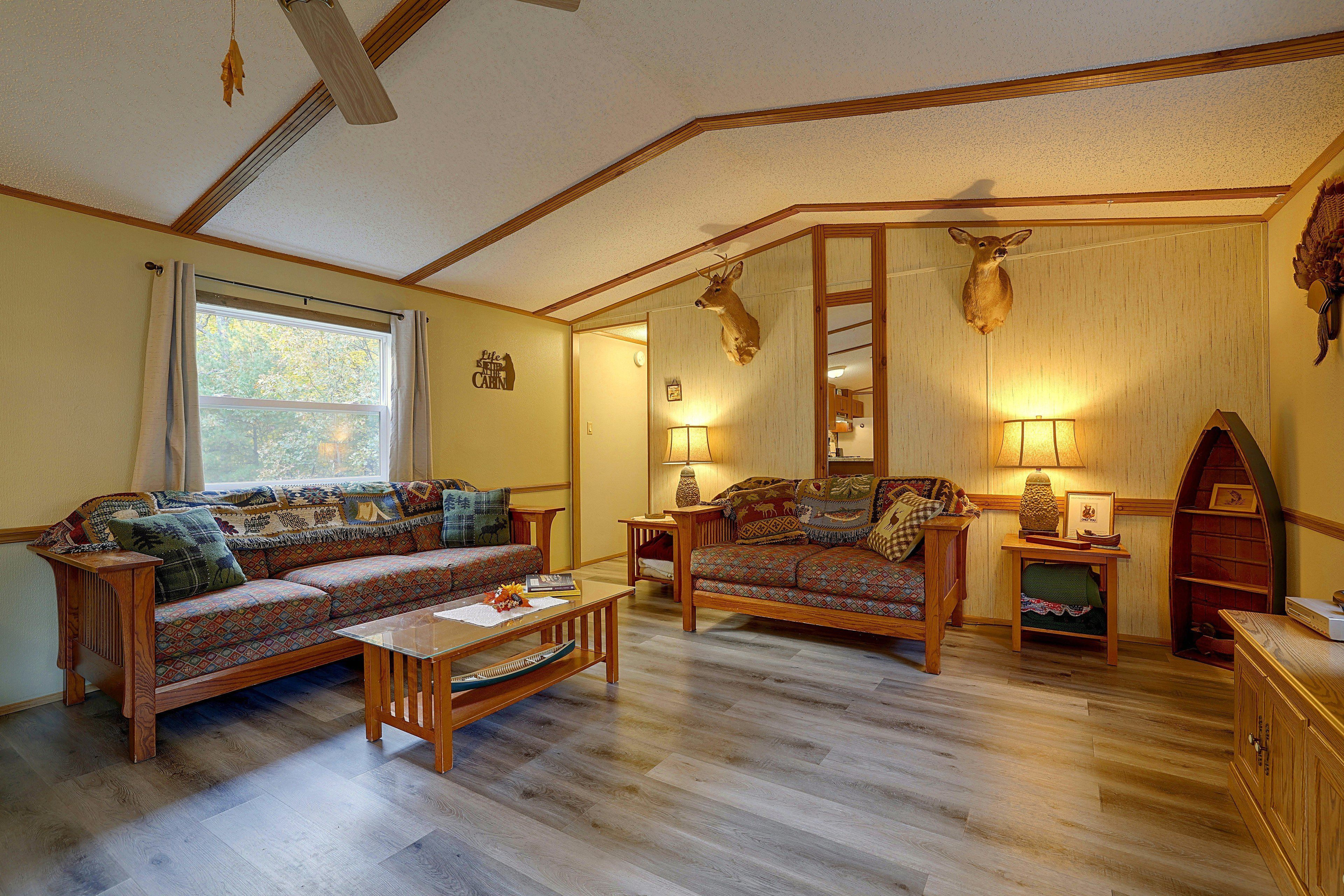 A cozy living room with a large sofa, a smaller sofa, a coffee table, and a fireplace.