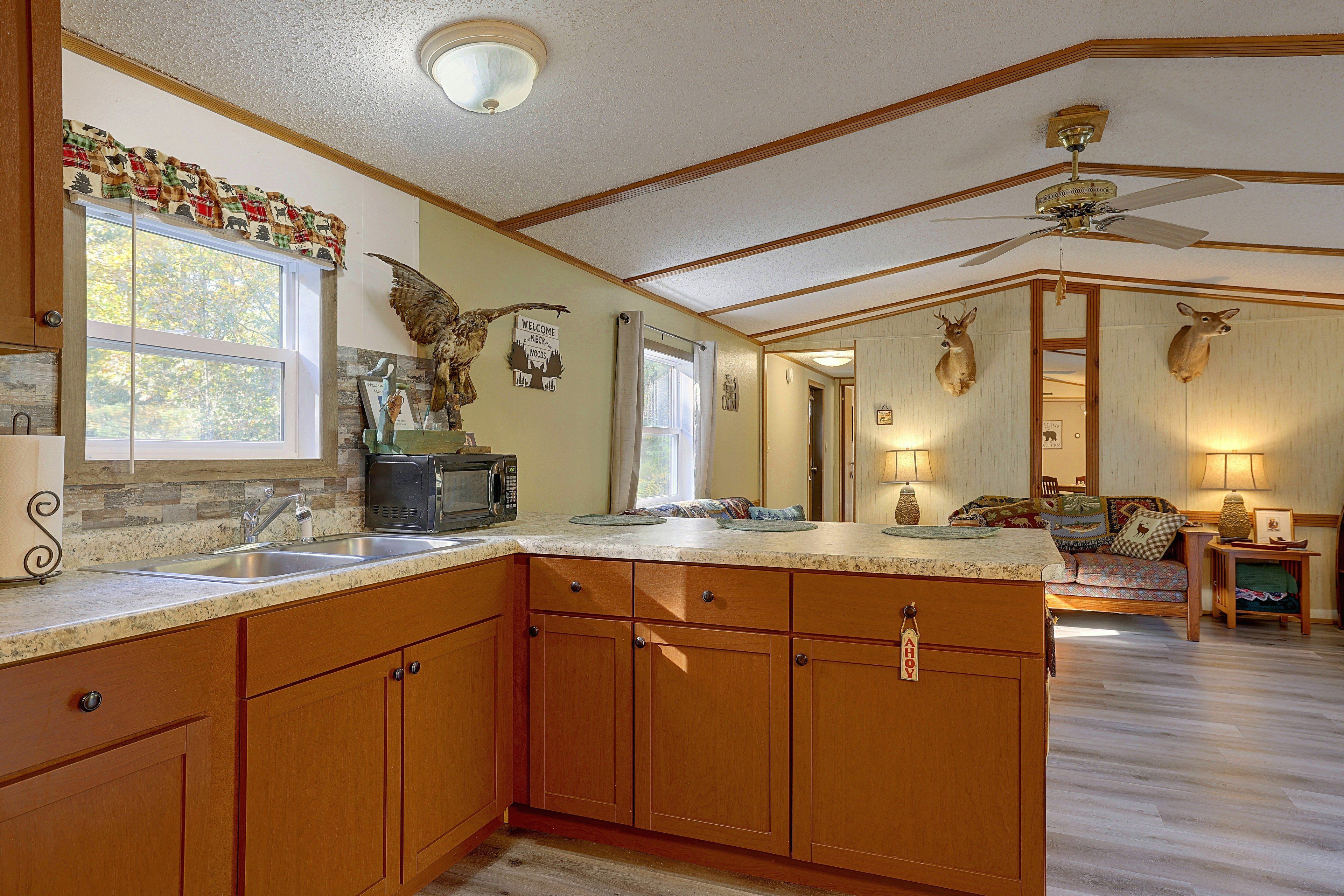 A spacious kitchen with wooden cabinets, a large island, and a ceiling fan.