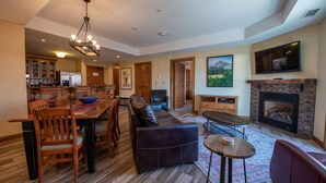 A spacious living area with a dining table, sofa, and fireplace.