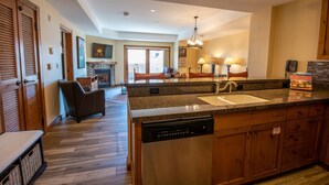 A spacious kitchen with a dishwasher, granite countertop, and wooden cabinets.