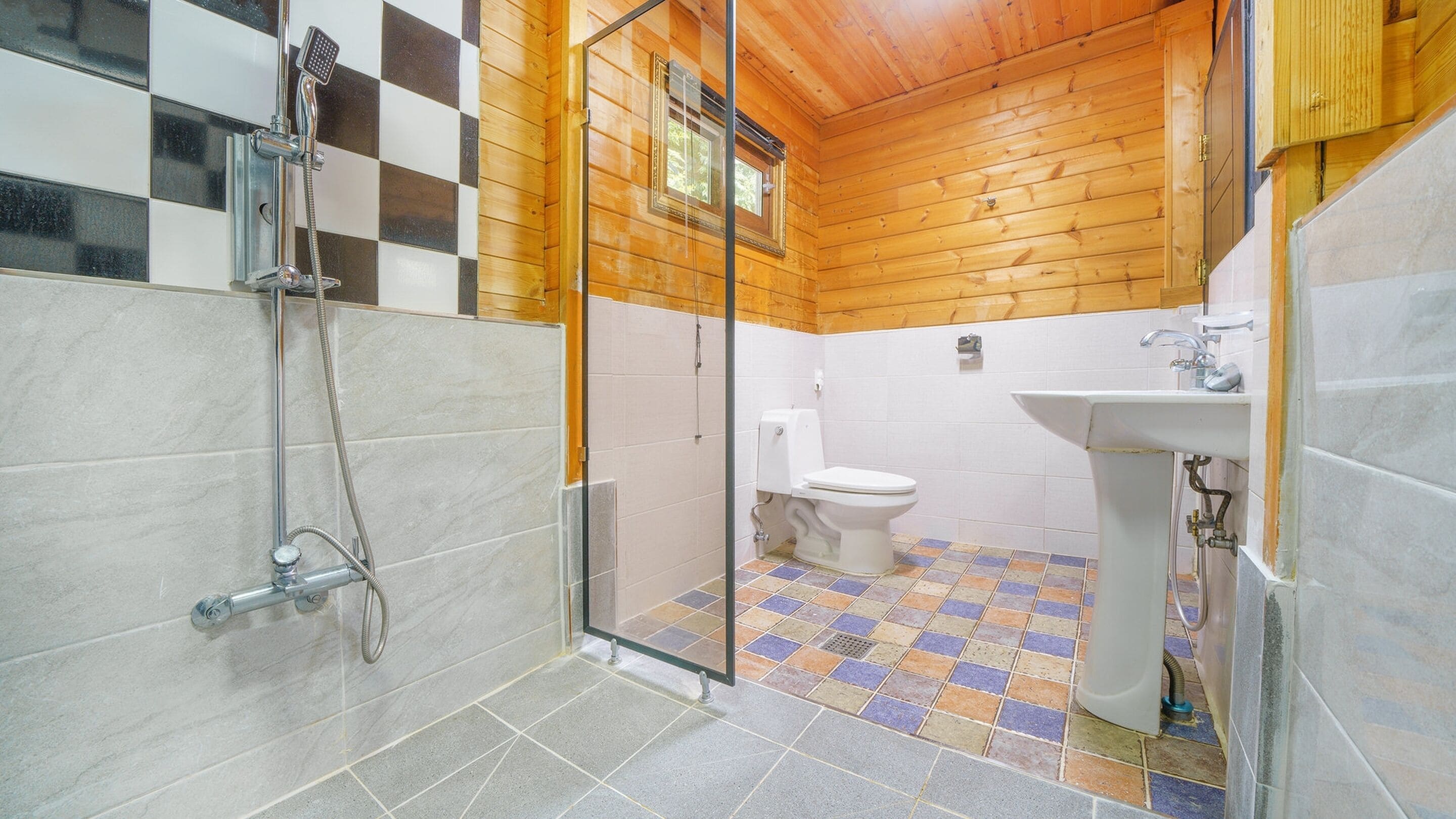 A bathroom with a shower, toilet, and sink.