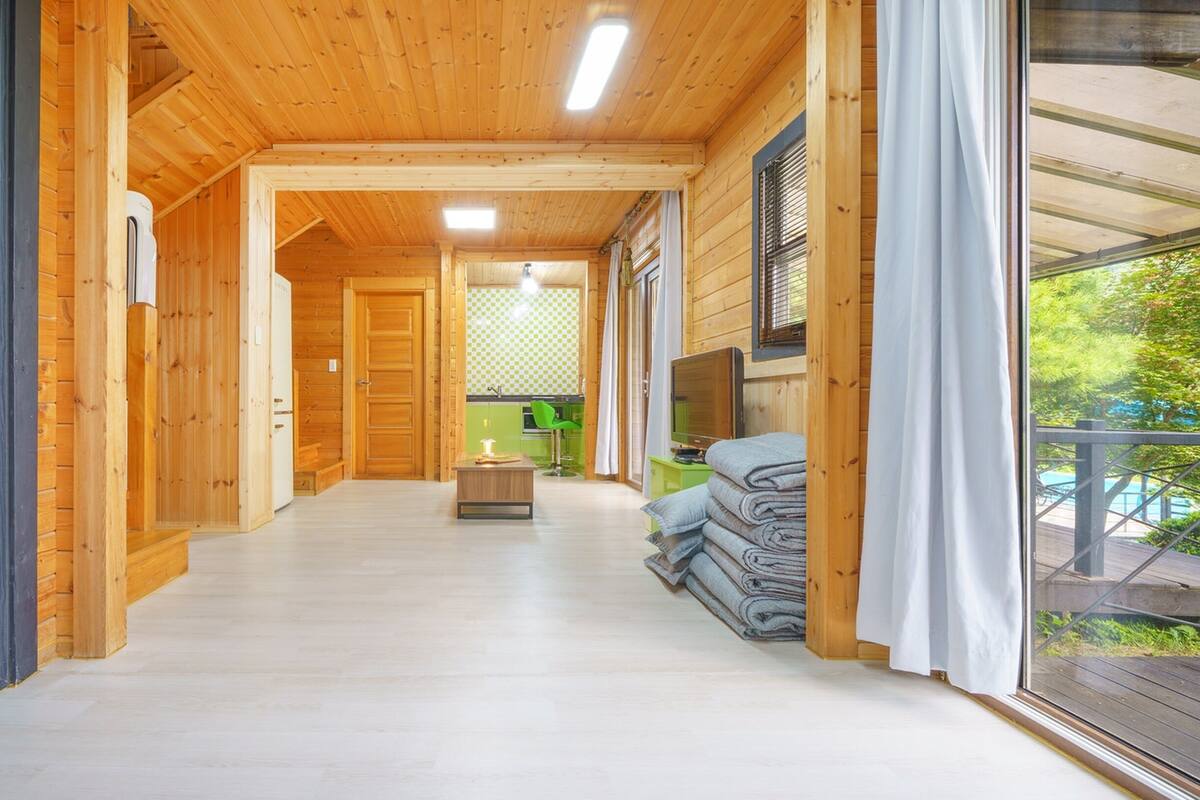 A wooden interior with a long hallway leading to a kitchen area.