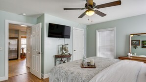 A bedroom with a bed, a ceiling fan, a television, and a window with blinds. - Pet-Friendly Lakehouse: View Tower + Fire Pit! (Leesville)