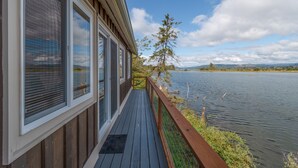 A wooden deck with a view of a lake and distant mountains. - Dog Friendly Puget Island Home on the Columbia River. Secure Private Moorage!! (Cathlamet)