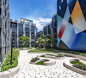 Stunning building with landscaped areas, palm trees, and a vibrant mural.