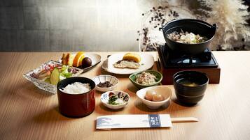 A traditional Japanese meal setup with various dishes and a teapot on a wooden table.