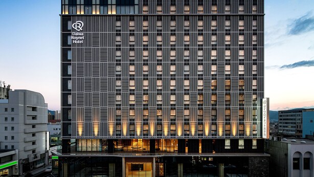 Un hotel Daiwa Roynet con una fachada moderna, varios pisos y ventanas iluminadas.