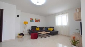 Sala de estar com sofá, mesa de centro, luminária de chão e planta em vaso.