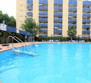 A swimming pool with a metal ladder, surrounded by a building with multiple balconies. - New Alboran Salou, heated, pool and wifi (Salou)