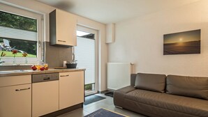 Une cuisine moderne avec une fenêtre, un radiateur, un canapé et un tableau accroché au mur.