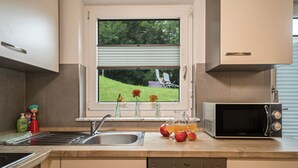 Une cuisine équipée d’une fenêtre, d’un évier, d’une cuisinière, d’un four à micro-ondes et d’un lave-vaisselle.