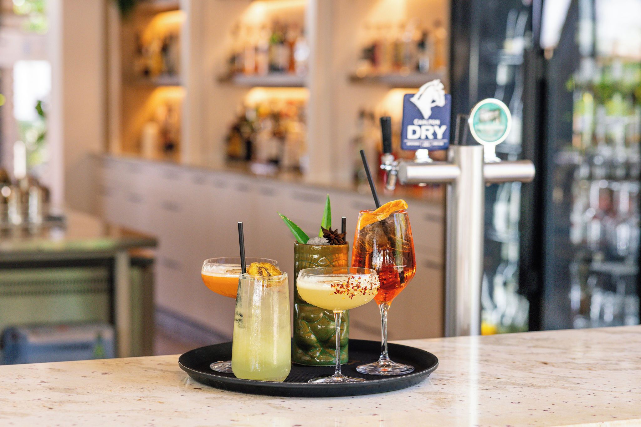 A bar area with a selection of drinks on a tray.