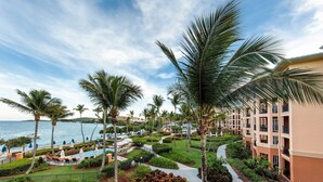 Un resort con piscina, palmeras y vistas al océano.
