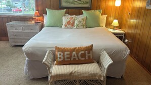 A bedroom with a large bed, a bench with a pillow, a dresser, a lamp, and a painting on the wall. - Charming Private Home - Walk to DT and the Beach! (Long Beach)