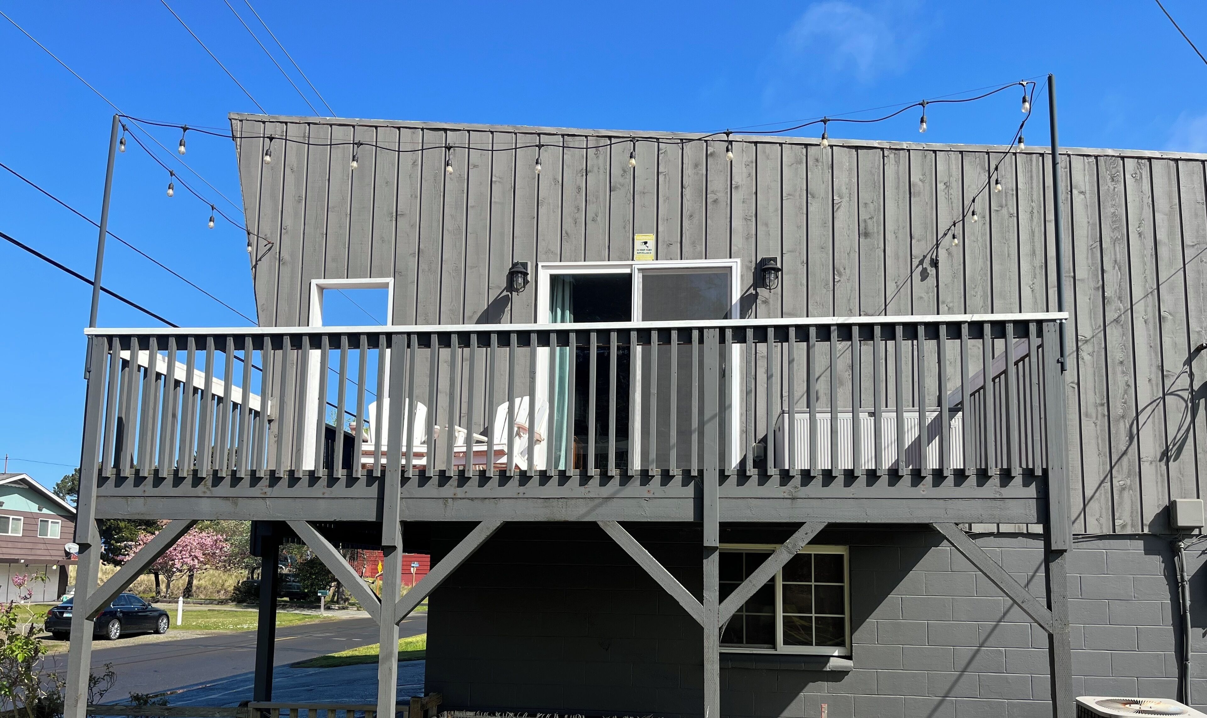 Un edificio de dos pisos con un balcón, una puerta y una ventana.