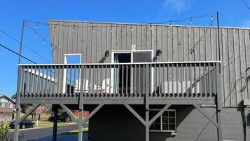 Un edificio de dos pisos con un balcón, una puerta y una ventana.
