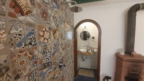 A bathroom with a mosaic tile wall, a sink, a mirror, and a wooden cabinet. - Room-dimora Aganoor Business Suite (Cava de' Tirreni)