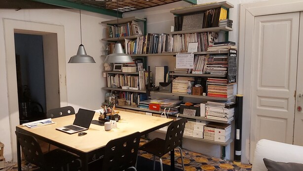 A study room with a desk, chairs, and a bookshelf filled with books and binders. - Room-dimora Aganoor Business Suite (Cava de' Tirreni)