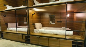 A bunk bed room with wooden walls and a small mirror on the wall. - Mayura Aureole Co-living - Hostel (Mumbai)