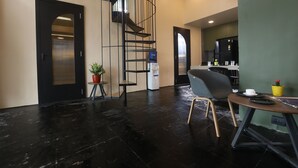 Un interior moderno con una escalera, un comedor con mesa y sillas, y una zona de cocina.